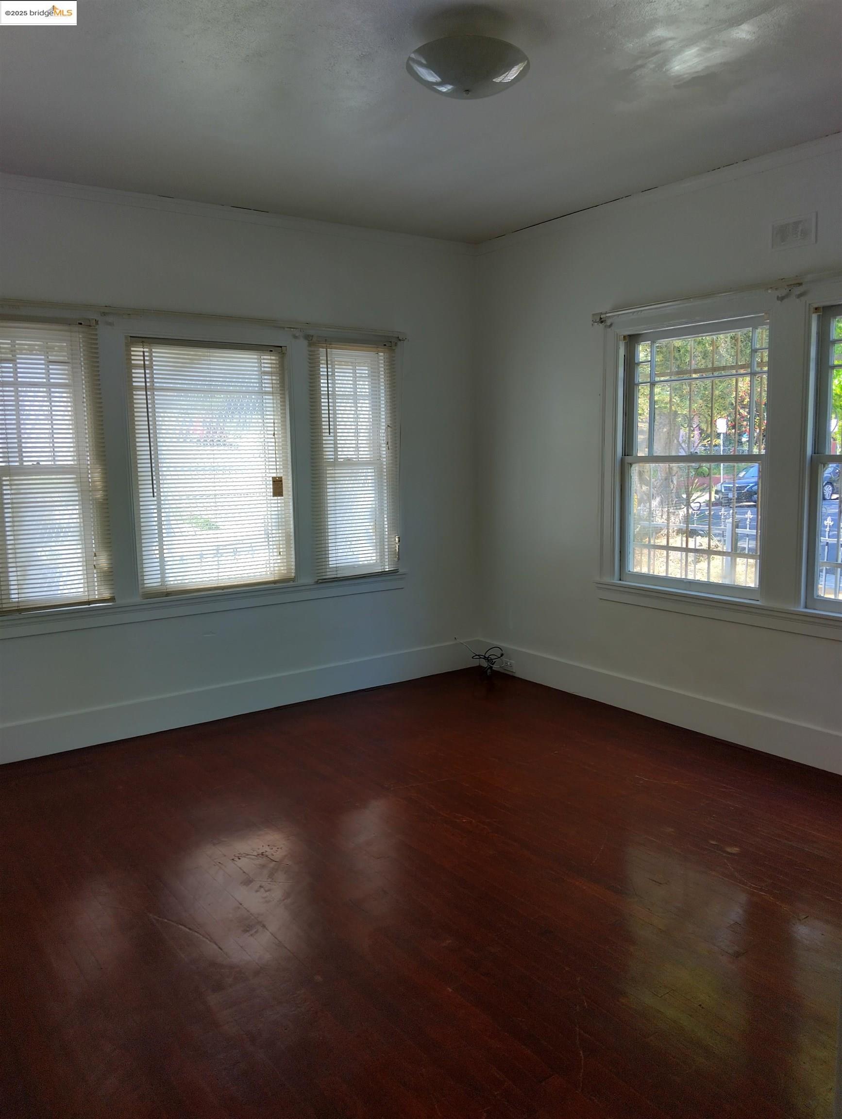 1864 11th Avenue Oakland, CA 94606 - Photo 15 of 46 an empty room with wooden floor and windows