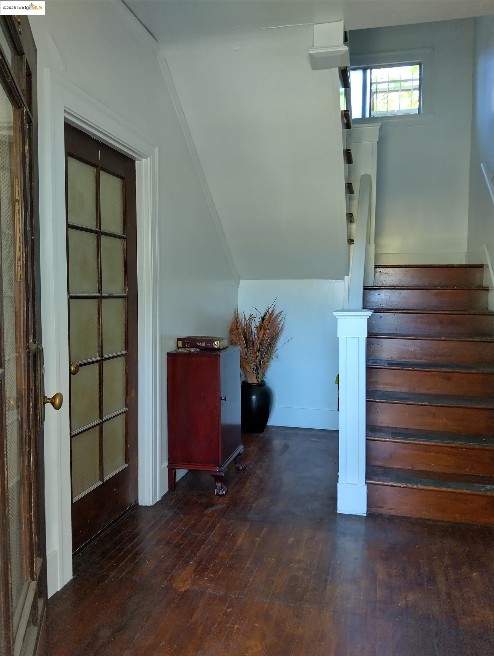 1864 11th Avenue Oakland, CA 94606 - Photo 45 of 46 an empty room with wooden floor staircase and windows