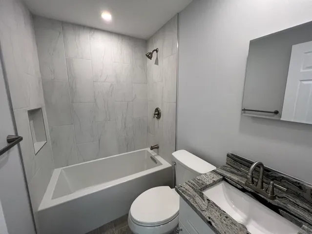 a white toilet sitting next to a bath tub