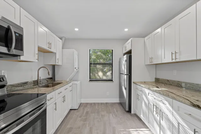 a kitchen with stainless steel appliances granite countertop a sink stove and refrigerator