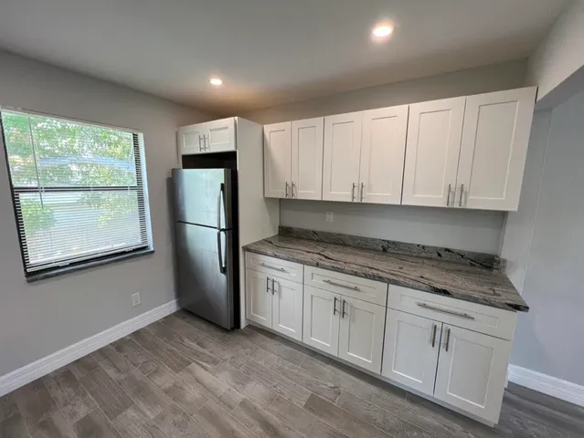 a kitchen with a refrigerator sink and cabinets