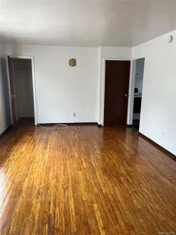 an empty room with wooden floor and closet