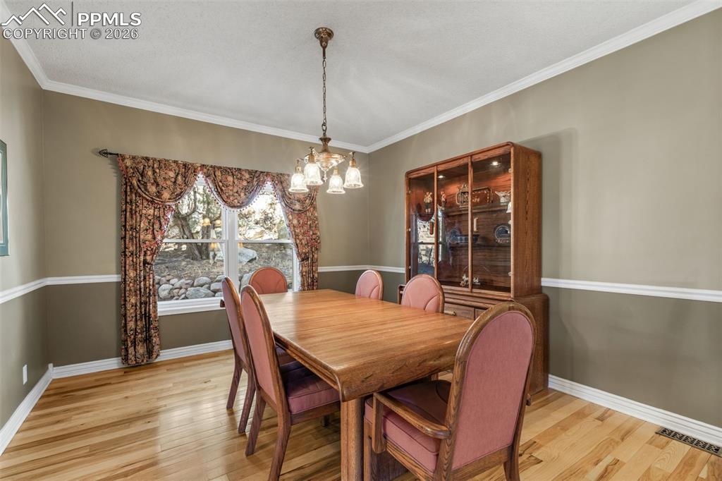 5440 Setters Way Colorado Springs, CO 80919 - Photo 12 of 40 a view of a dining room with furniture window and wooden floor