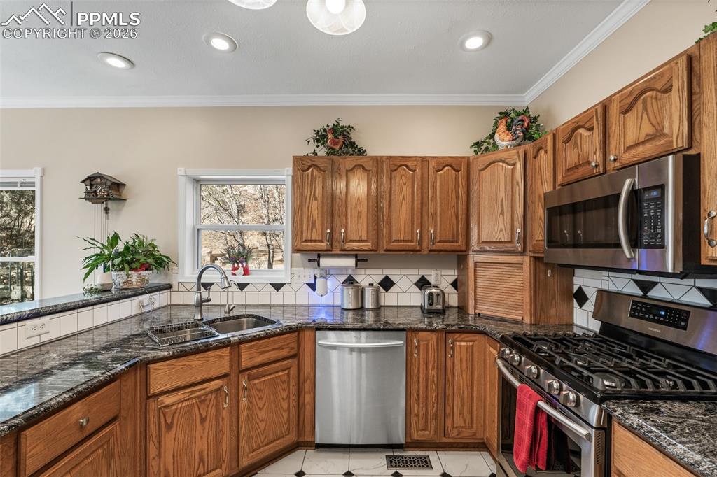 5440 Setters Way Colorado Springs, CO 80919 - Photo 15 of 40 a kitchen with stainless steel appliances a sink stove and cabinets