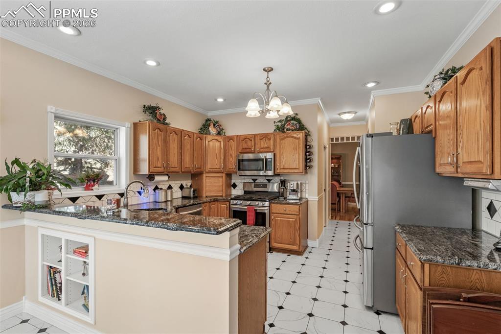 5440 Setters Way Colorado Springs, CO 80919 - Photo 16 of 40 a kitchen with stainless steel appliances kitchen island granite countertop a sink stove and refrigerator