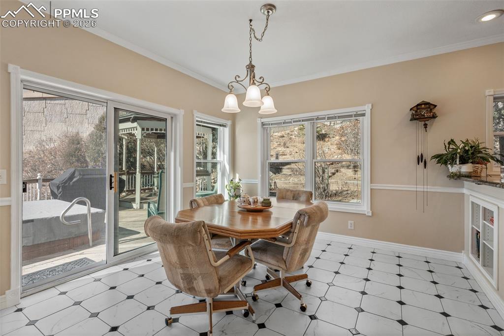 5440 Setters Way Colorado Springs, CO 80919 - Photo 17 of 40 a dining room with furniture a chandelier and wooden floor