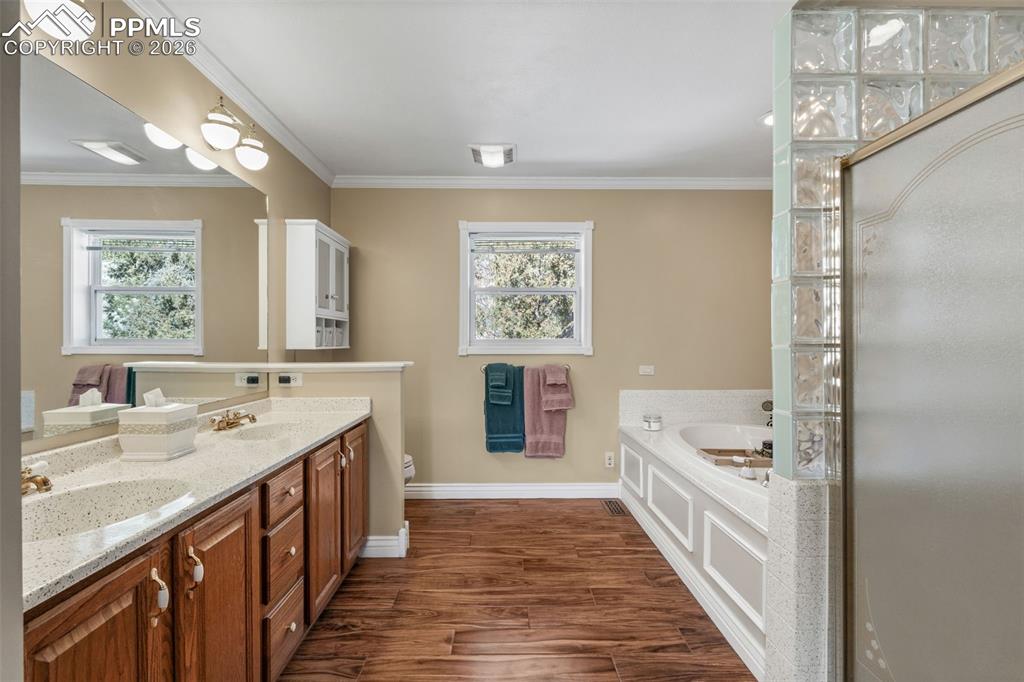 5440 Setters Way Colorado Springs, CO 80919 - Photo 26 of 40 a spacious bathroom with a double vanity sink a large mirror and a shower