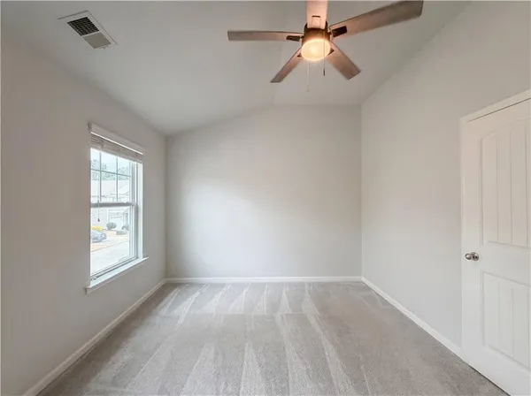 an empty room with windows and fan