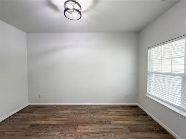 a view of a livingroom with wooden floor and a window