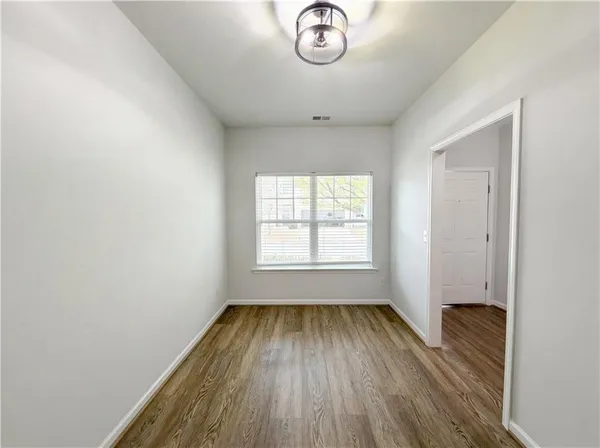 an empty room with a hardwood and a window