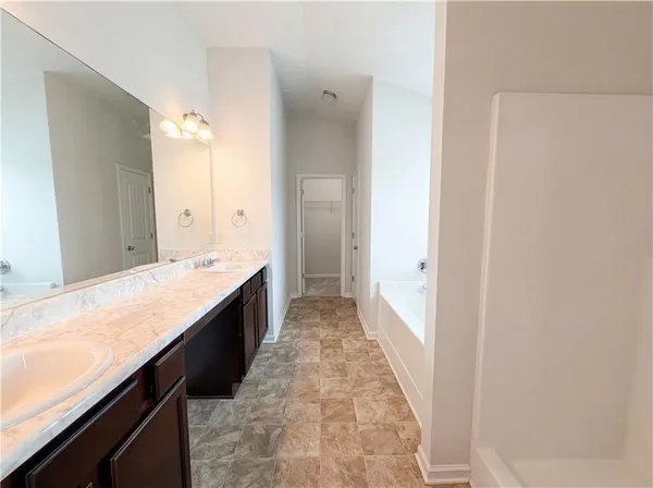 a spacious bathroom with a granite countertop sink