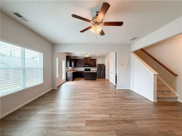 a view of empty room with wooden floor and windows