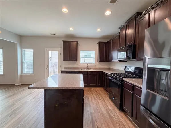 a kitchen with granite countertop stainless steel appliances and wooden cabinets