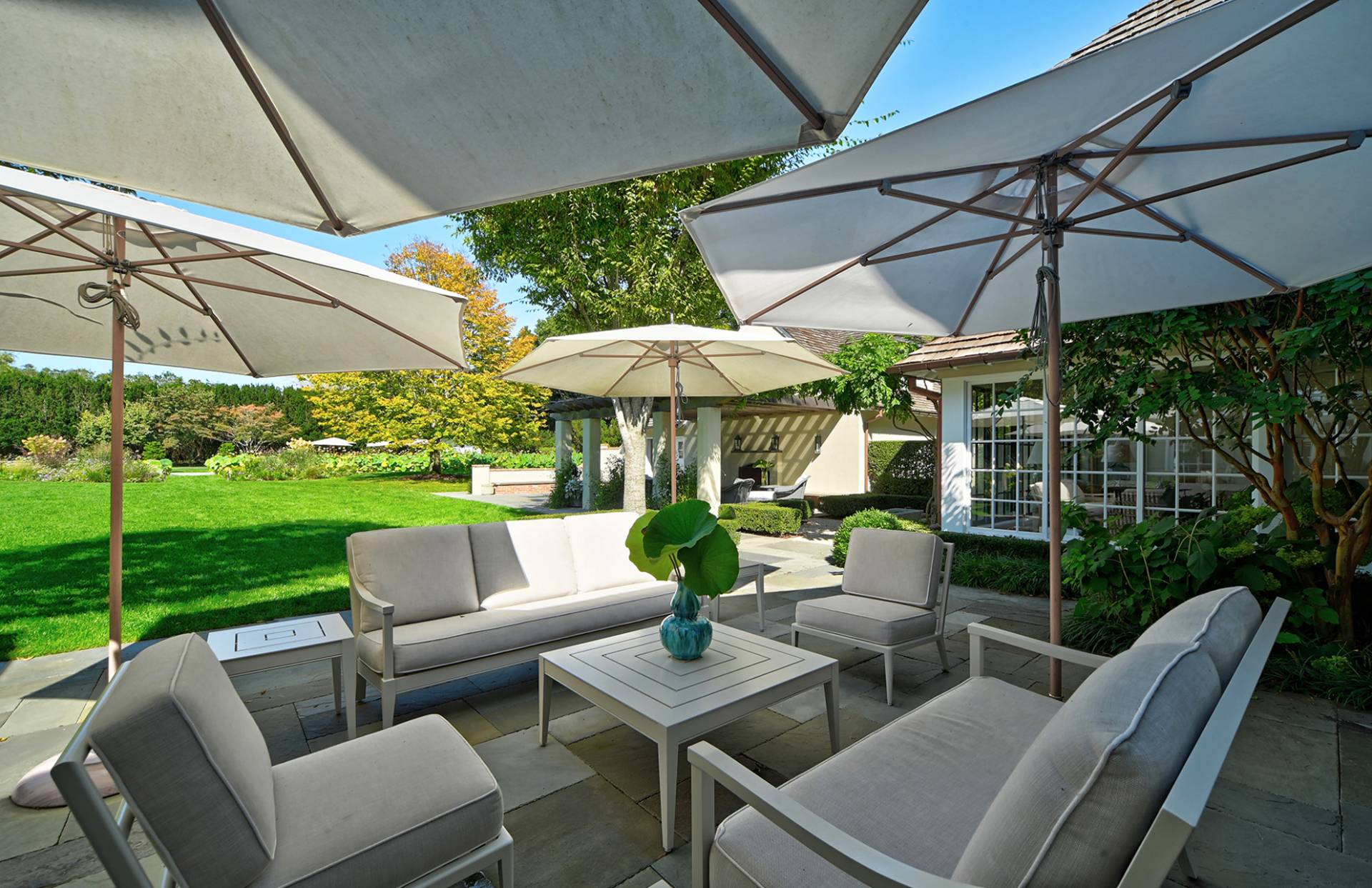 63 Middle Lane East Hampton, NY 11937 - Photo 7 of 39 a view of a patio with couches chairs under an umbrella