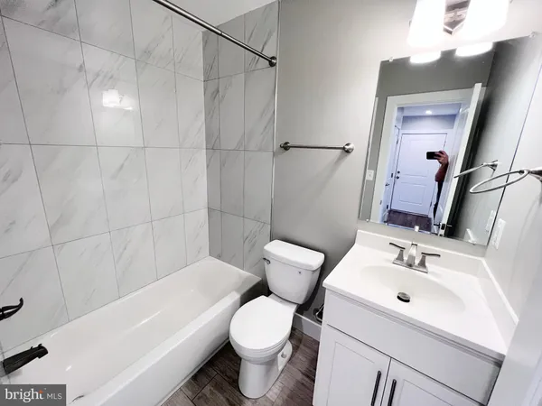 a view of an empty room with closet and wooden floor