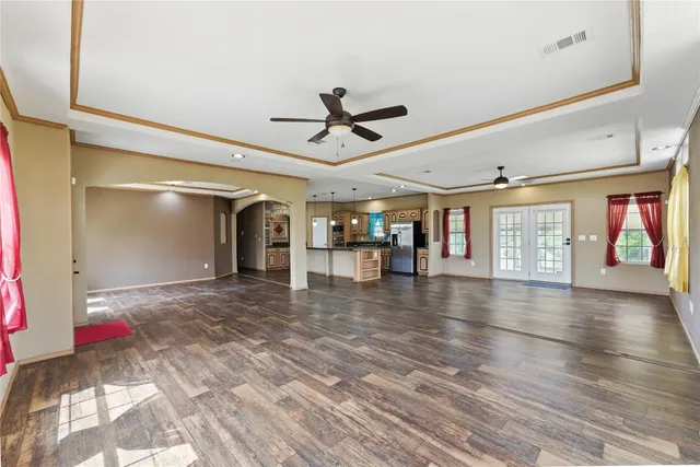 a view of an empty room with a window and a kitchen