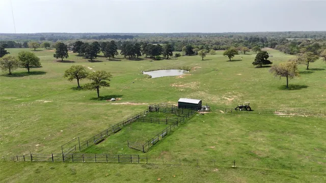 an aerial view of residential house with outdoor space and trees all around