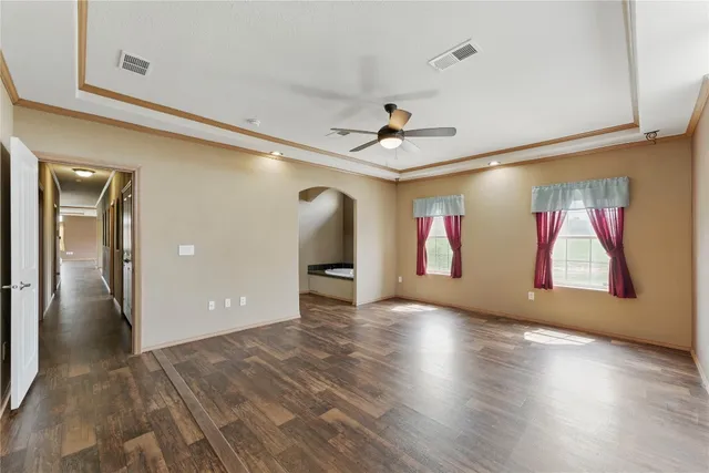 a view of a livingroom with wooden floor and a ceiling fan