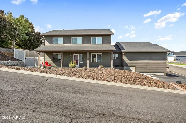 a front view of a house with a road and a yard