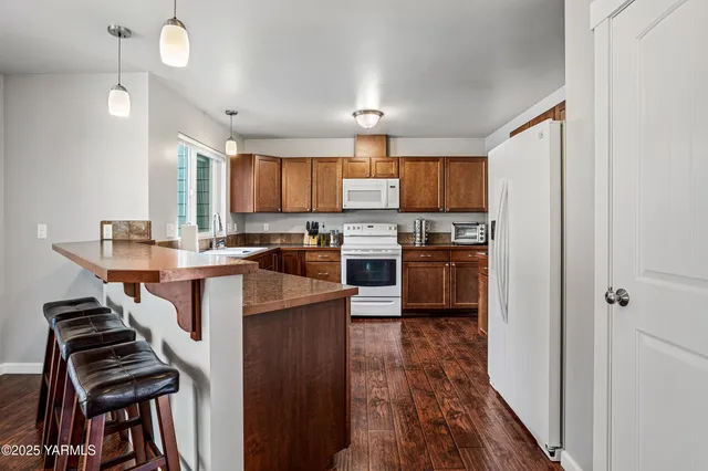 a kitchen with stainless steel appliances granite countertop a stove refrigerator and a microwave