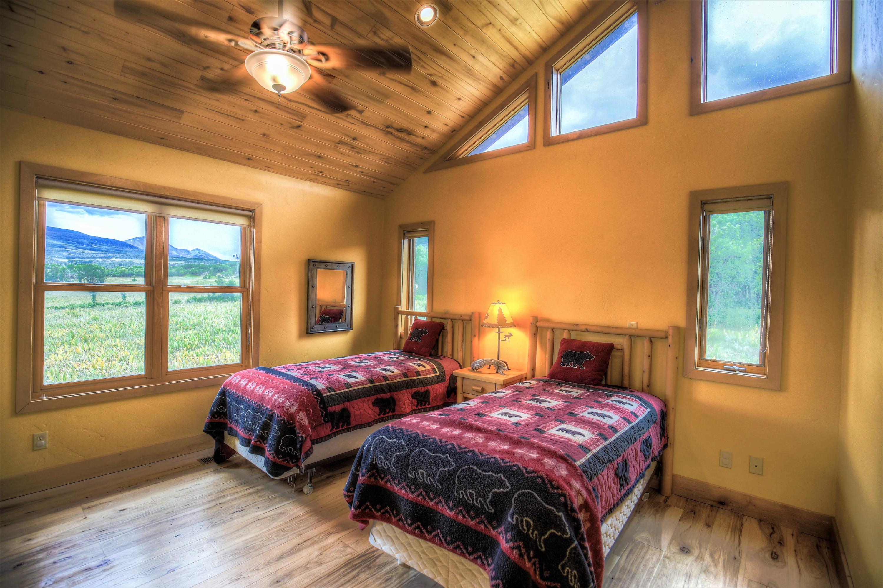 390 Peninsula Drive Placerville, CO 81430 - Photo 21 of 37 a bedroom with two beds and a chandelier