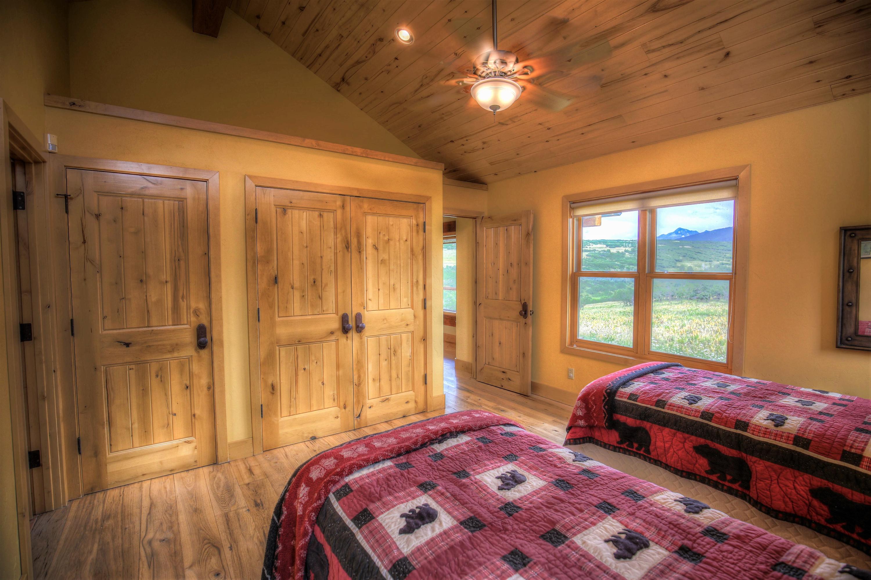 390 Peninsula Drive Placerville, CO 81430 - Photo 23 of 37 a bedroom with a bed and a chandelier