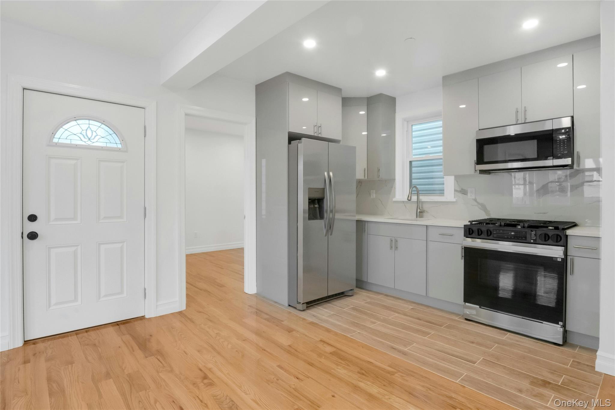 25 Walnut Street New Rochelle, NY 10801 - Photo 5 of 29 a kitchen with stainless steel appliances kitchen island granite countertop a stove a sink and a refrigerator