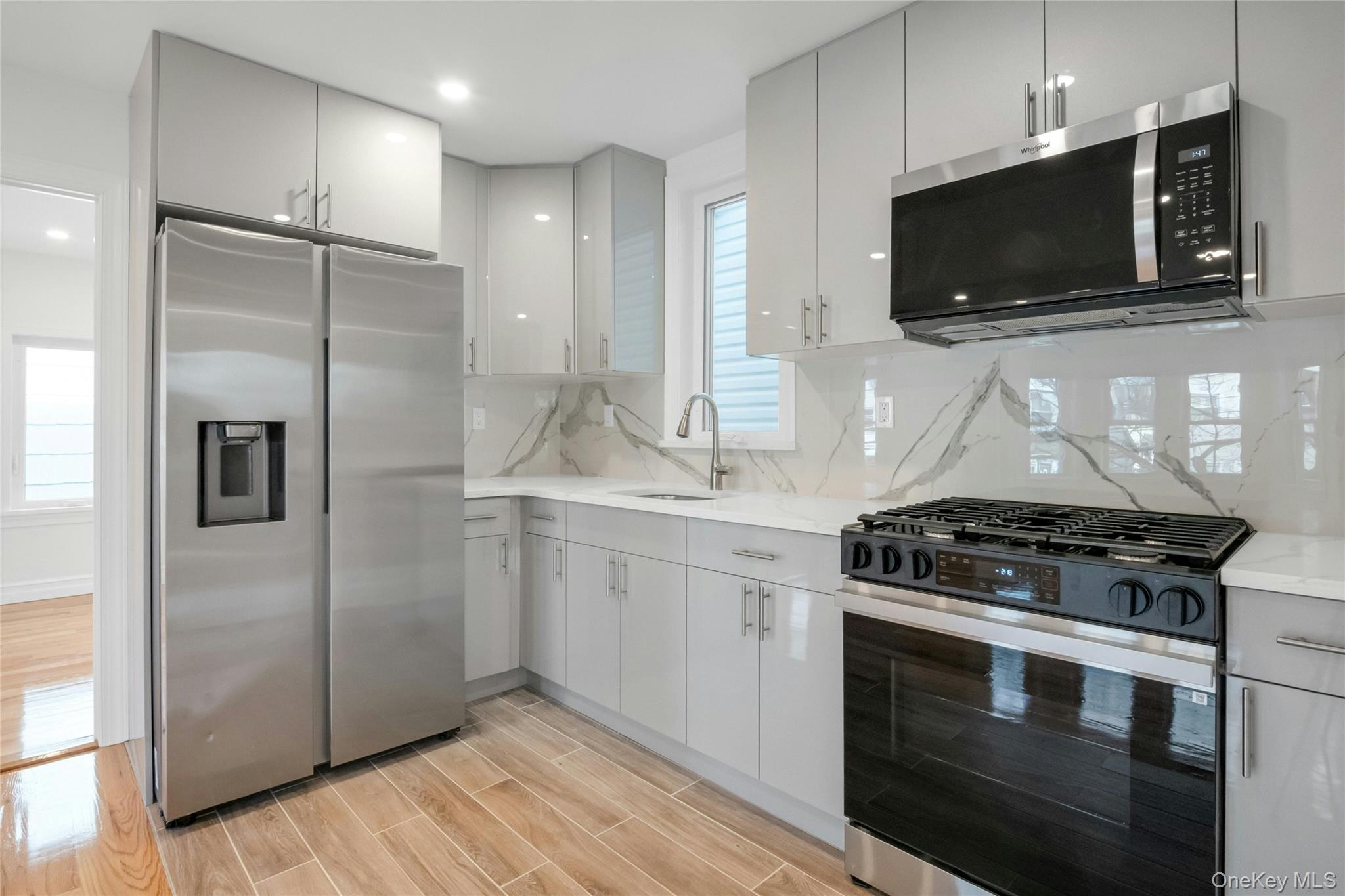 25 Walnut Street New Rochelle, NY 10801 - Photo 6 of 29 a kitchen with stainless steel appliances kitchen island granite countertop a stove and a microwave