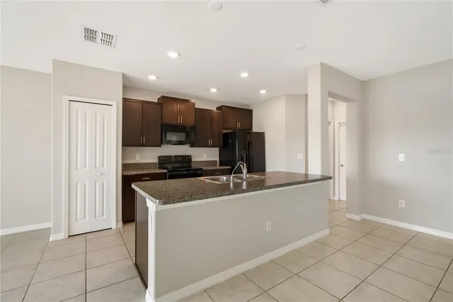 a kitchen with stainless steel appliances granite countertop a sink and a refrigerator