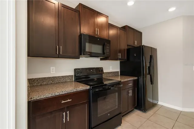 a kitchen with granite countertop wooden cabinets and stainless steel appliances