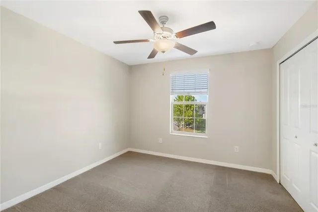 an empty room with a window and a fan