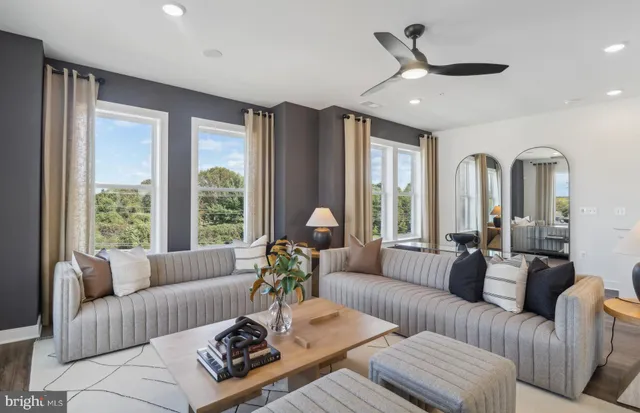 a living room with furniture kitchen view and a chandelier