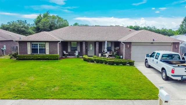 a front view of a house with a garden and trees