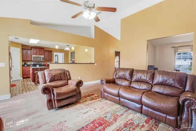 a living room with furniture ceiling fan and a rug