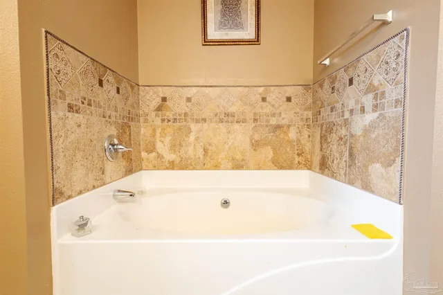 a spacious bathroom with a granite countertop tub sink and mirror