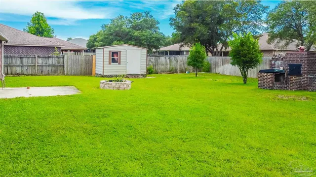a view of a backyard with table and chairs potted plants and wooden fence