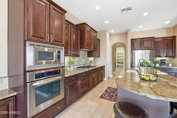 a kitchen with a sink a stove cabinets and wooden floor
