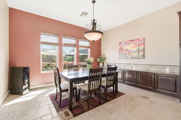 a view of a patio with a table and chairs under an umbrella