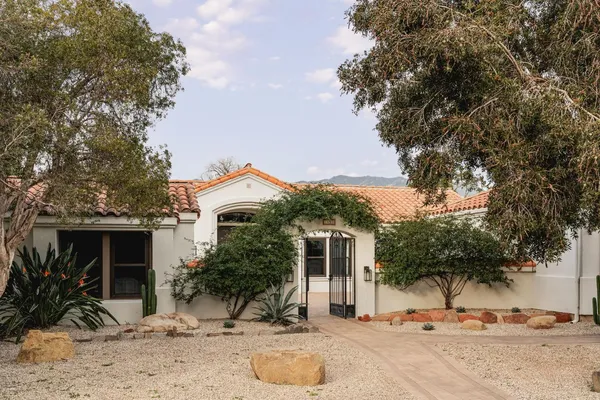 a view of a house with a yard and large tree