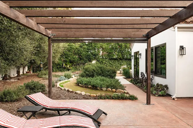 a backyard of a house with yard fountain and outdoor seating