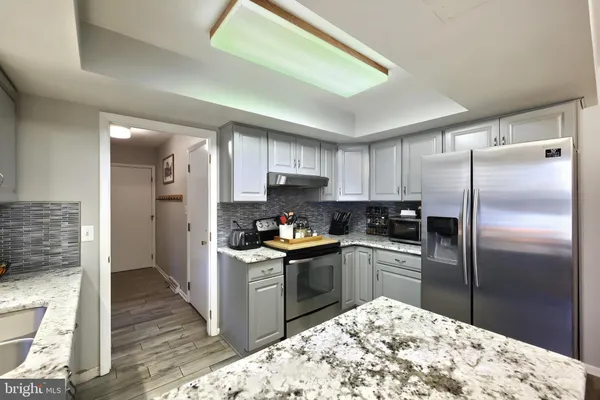 a kitchen with stainless steel appliances granite countertop a refrigerator sink and cabinets
