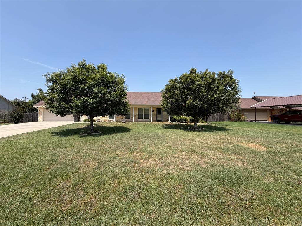 313 East River Oaks Road Early, TX 76802 - Photo 2 of 34 Spacious residential property featuring a single-story brick and stone exterior with a pitched roof, set on an expansive manicured lawn anchored by two mature shade trees