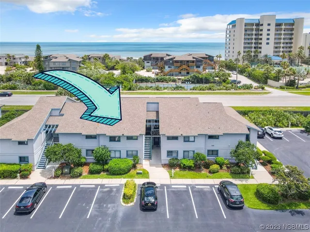 an aerial view of a house with a yard and outdoor seating