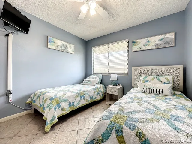 a bedroom with two beds and a flat screen tv