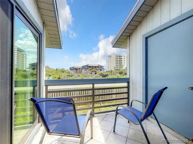 a view of a chairs and table in the balcony