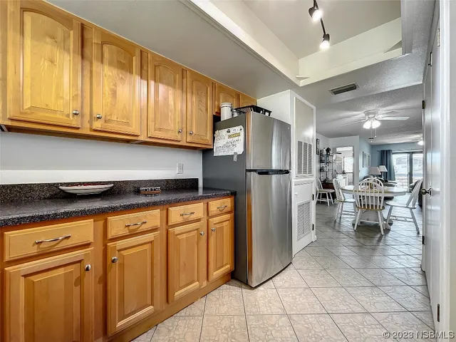 a kitchen with stainless steel appliances kitchen island granite countertop a refrigerator and cabinets