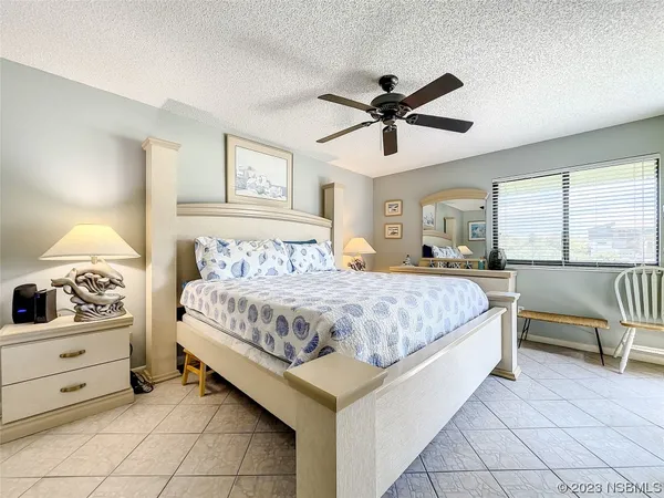 a spacious bedroom with a bed and ceiling fan
