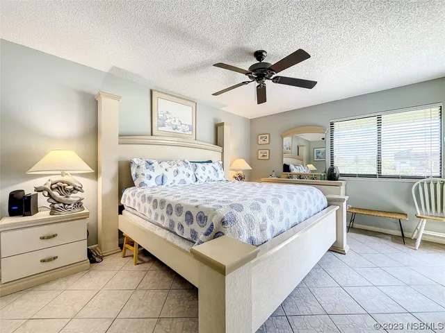 a spacious bedroom with a bed and ceiling fan