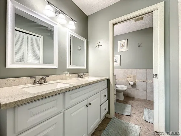 a spacious bathroom with a granite countertop sink toilet and mirror