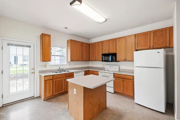 a kitchen with stainless steel appliances granite countertop a sink stove refrigerator and cabinets